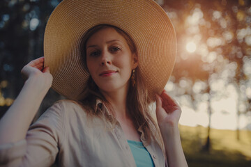 Wall Mural - Portrait of beautiful woman wearing hat at sunset light