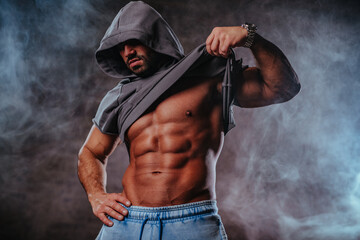 Wall Mural - Strong man bodybuilder with hood portrait