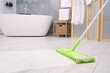 Washing floor with mop in bathroom, space for text. Clean trace on dirty surface