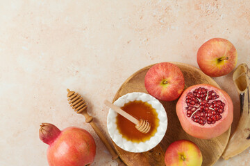 Jewish holiday Rosh Hashanah concept with honey, apple and pomegranate on stone background. Top view, flat lay