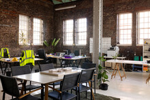 Modern Creative Office Interior With Exposed Brick Walls, Desks And Chairs