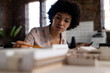© Wavebreak Media - Biracial female architect sitting at desk using smartphone and looking at building model in office