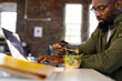 © Wavebreak Media - African american casual businessman using laptop and eating takeaway salad sitting at desk in office