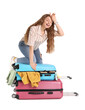 © Pixel-Shot - Tired young woman trying to close suitcase with a lot of things on white background