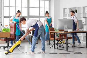 Canvas Print - Young janitors cleaning in office