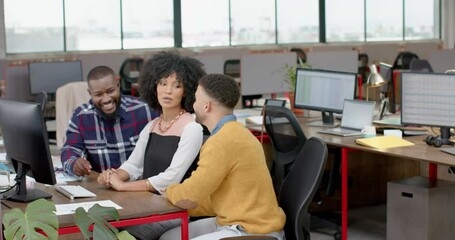 Wall Mural - three happy diverse colleagues discussing over a computer at office