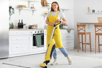 Canvas Print - Young woman vacuuming carpet in kitchen