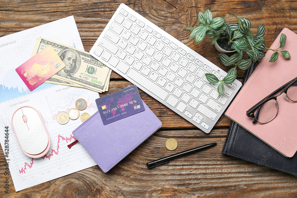 Credit cards with notebooks and keyboard on wooden table