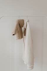 Wall Mural - Fluffy woolen baby and adult jackets on hanger. Minimalist fashion wardrobe background