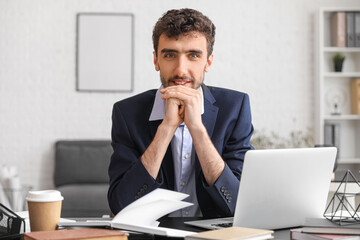 Poster - Young businessman working at table in office