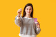 © Pixel-Shot - Young woman with box of tampons on orange background