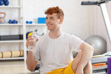 Sticker - Young redhead man with bottle of water in gym