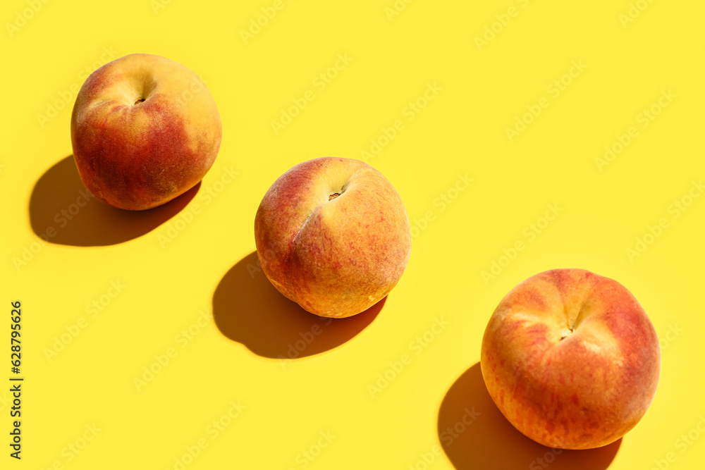 Sweet peaches on yellow background
