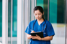 Asian Nurse Or Doctor With Stethoscope And Clipboard In Hospital.