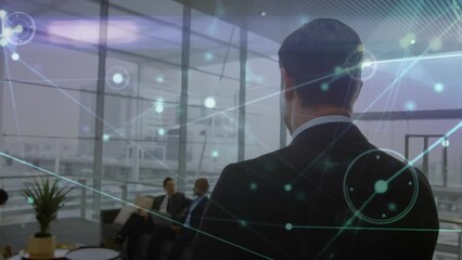 Poster - Animation of network of connections over rear view of a caucasian businessman walking at office