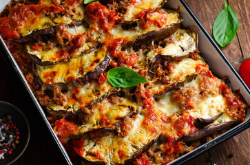 Wall Mural - Eggplant Casserole, Roasted Eggplant Dish with Minced Meat, Tomato Sauce and Mozzarella over Rustic Background