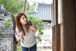 © PHOTOGRAPHER JH - A young woman, a college student, traveling in a traditional Korean village with a backpack