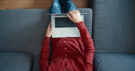 Man sit in coach open laptop computer and typing on keyboard