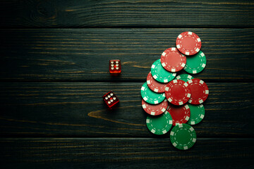 A lot of poker chips and two dice with a winning combination on a dark table. Luck in gambling depends on fortune