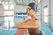 © Ilzer/peopleimages.com - Thinking, woman and swimming pool for fitness, exercise and competition training with vision, ideas or ready for race. Serious, athlete and swimmer in water sports gear for workout challenge practice