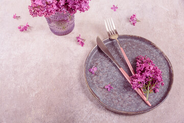 Wall Mural - Beautiful table setting with lilac flowers and purple fabric on light gray background. Holidays decoration for romantic dinner in restaurant. Top view with copy space for text