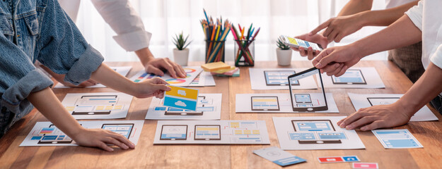 Poster - Panorama shot of front-end developer team brainstorming UI and UX designs for mobile app on paper wireframe interface. User interface development team planning for user-friendly UI design. Scrutinize