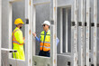 © NVB Stocker - building and construction worker, Hiapanic latin male wearing safety hard hat helmet standing at Prefabricated concrete walls Industry Manufacturing Factory. Unity and teamwork