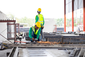 Labor man cutting steel at the construction site. Heavy Industry Manufacturing Factory. Prefabricated concrete walls. Asian worker wearing safety hardhat helmet