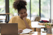 © Songsak C - A beautiful African American girl, student or businesswoman sitting at a desk and writing.