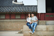 © Dialogue Frame - A college student couple looking for their way through a map during a trip to a traditional Korean house