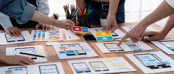 Wall Mural - panorama shot of front-end developer team brainstorming ui and ux designs for mobile app on paper wi