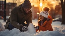 Father And Daughter Making A Snowman