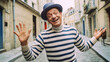 Charming mime artist in beret and stripes, humorously posed amid Montmartres quaint pastel streetscape in Paris, France. Generative AI