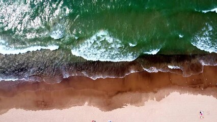 Wall Mural - Aerial top view of white sandy beach with green foamy waves