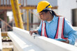 © NVB Stocker - African american women foreman checking quality of prefabricated concrete wall. Plus size female worker wearing safety hardhat working at heavy Prefabricated concrete walls manufacturing factory