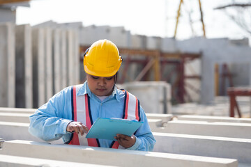 Wall Mural - African american women foreman checking quality of prefabricated concrete wall. Plus size female worker wearing safety hardhat working at heavy Prefabricated concrete walls manufacturing factory