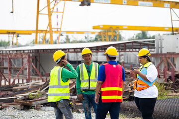 Wall Mural - Fat female construction manager working with Asian team worker construction at Prefabricated concrete walls factory. Safety hard hat helmet