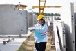 © NVB Stocker - Portrait African american woman. Plus size female factory worker wearing safety hard hat helmet working at heavy Prefabricated concrete walls manufacturing factory