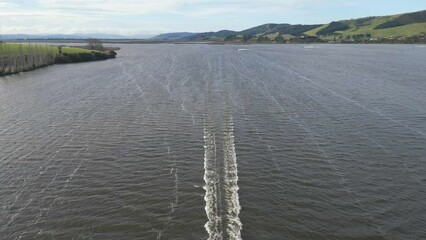 Poster - Drone footage of a speed boat sailing in the lake with green hills