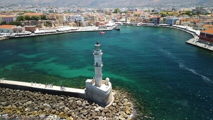 Sticker - Aerial shot of a tranquil body of water with a lighthouse standing on its shore in Chania, Greece.