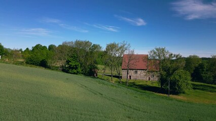 Sticker - Raising drone over Berg Old Church (Berg steinkirke) with countryside fields in Larvik, Norway