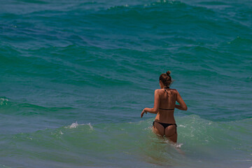 Wall Mural - Woman in black swimsuit on the shore