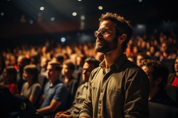 A man is asking a question to a speaker during a Q&A session at an international technical conference in a darkened auditorium. the young expert shows off