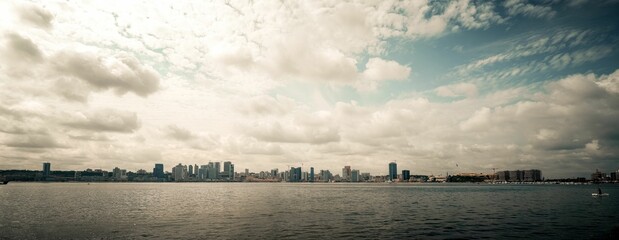 Sticker - Stunning panoramic view of the bustling Luanda cityscape with a body of water in the foreground