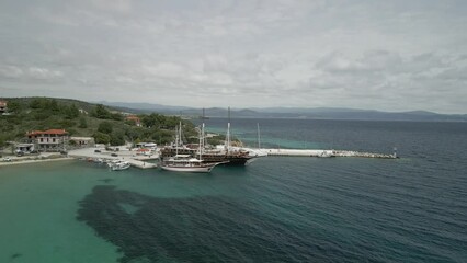 Canvas Print - Drone shot over a coastal hotel with harbor on calm sea water