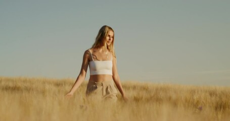 Sticker - Blonde beautiful woman walking in the wheat field on a sunny day