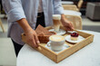 © Shi  - Happy smiling handsome woman waiter in a restaurant holding a tray with a latte coffee, cappuccino and berry cake in a restaurant. High quality photo