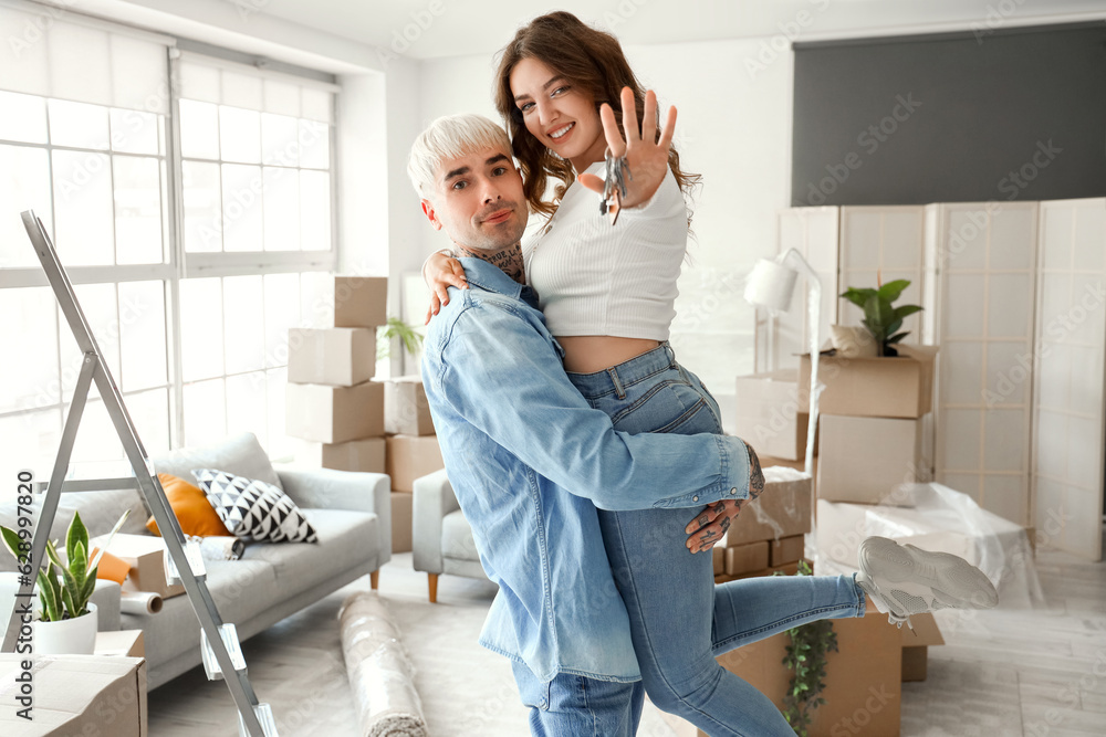 Happy young couple in room on moving day