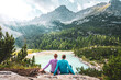 © Michael - Young sportive couple enjoys view on the turquoise Sorapis lake from a beautiful restpoint in the afternoon. Lake Sorapis, Dolomites, Belluno, Italy, Europe.