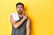 © Asier - Sporty Caucasian man with towel, studio shot on yellow Sporty Caucasian man with towel, studio shot on yellowpointing to the side